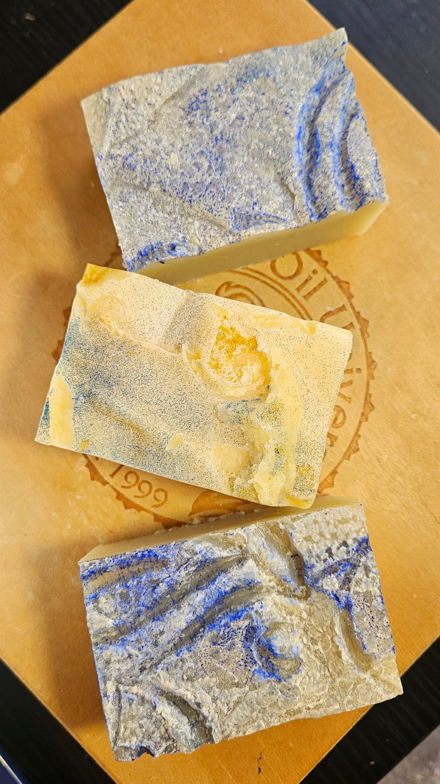 Three soap bars with a marbled pattern on a cardboard background