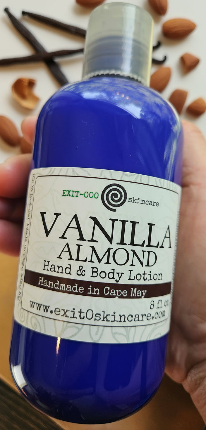 Vanilla Almond hand and body lotion bottle with vanilla beans and almonds in the background