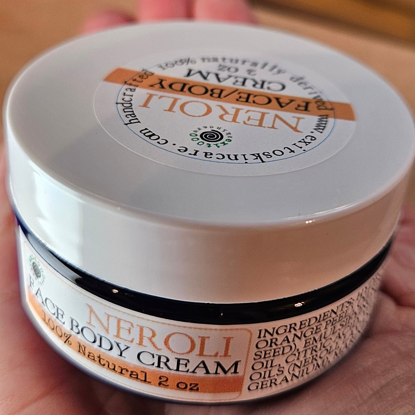 Hand holding a jar of Natura Bissé skincare product with a blurred background