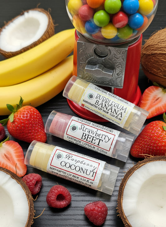 Three lip balm tubes with different flavors on a wooden surface