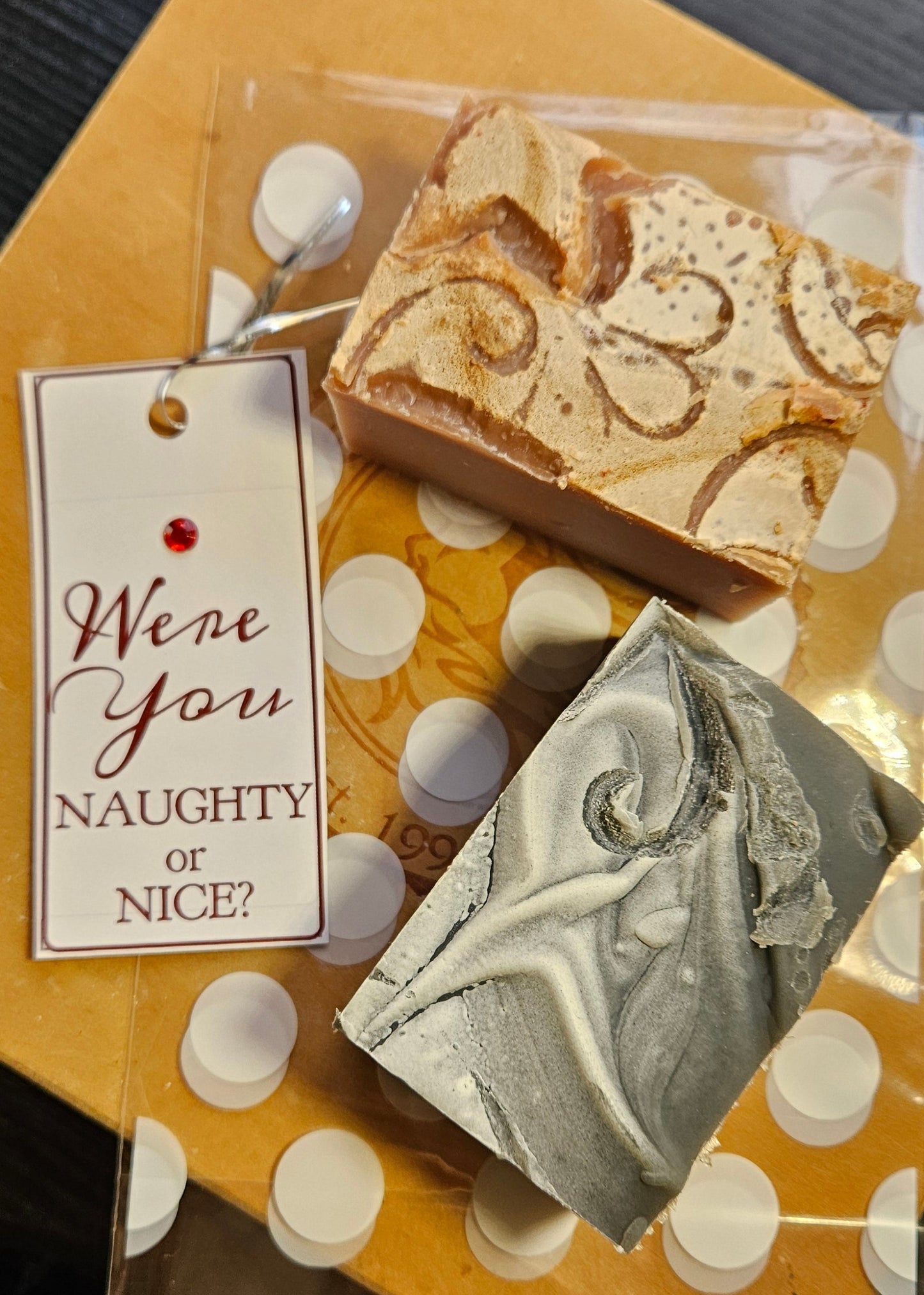 Two soap bars on a polka dot stand with a decorative tag.