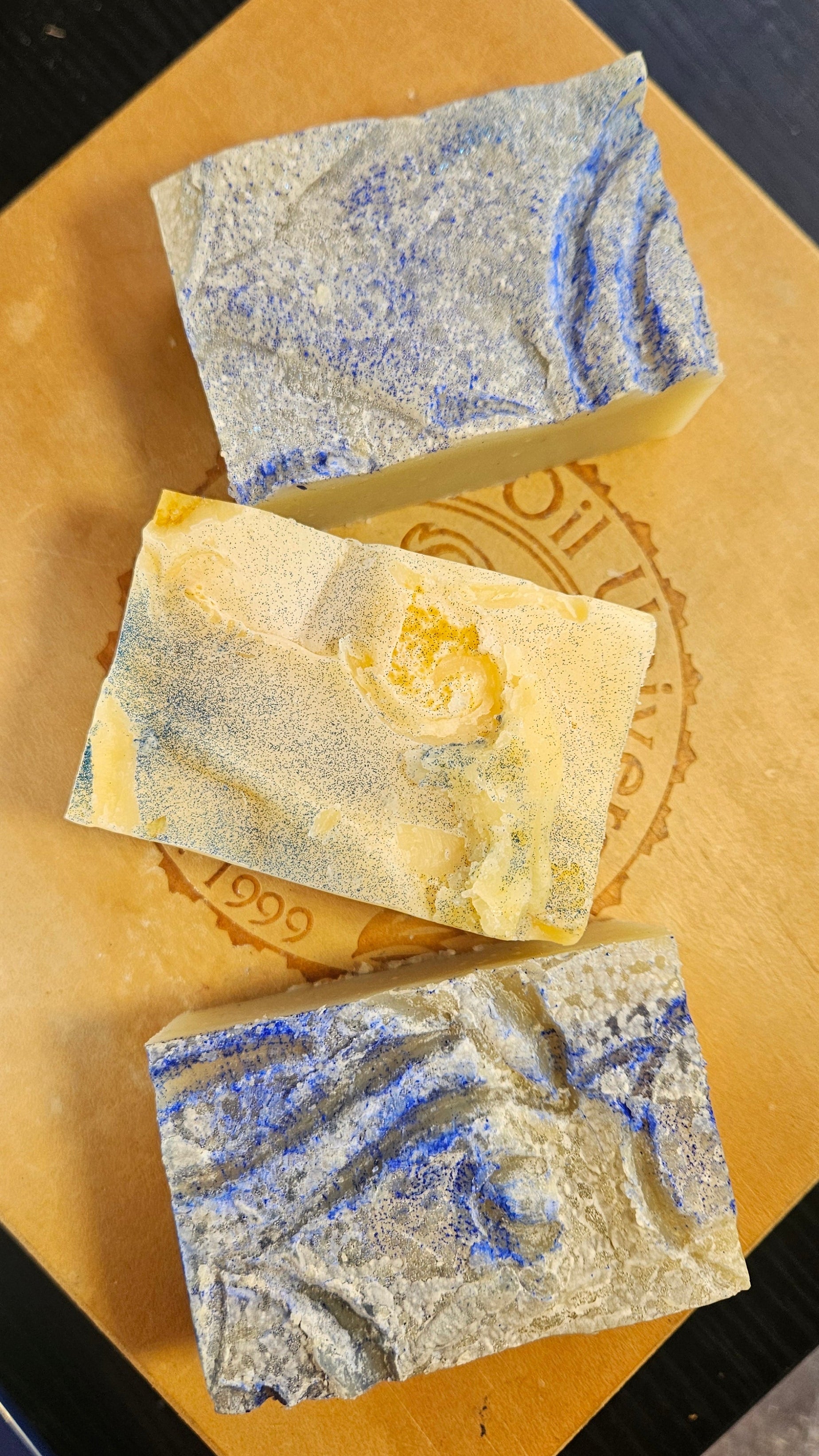 Three soap bars with a marbled pattern on a cardboard background