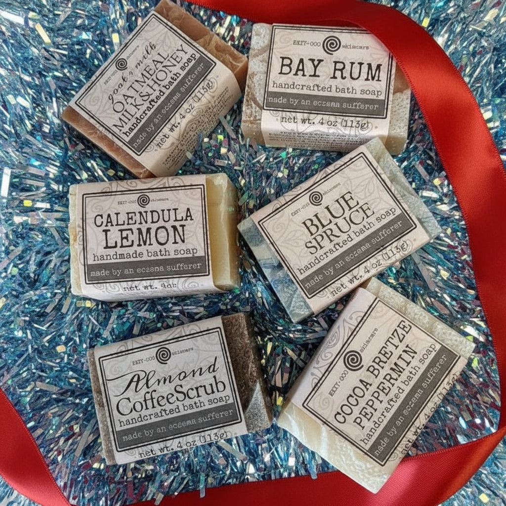 Handmade bath soap bars with labels on a decorative surface with a red ribbon.