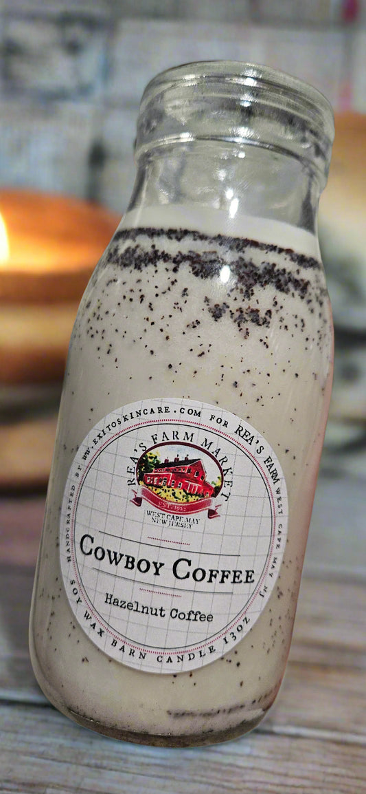 Bottle of Cowboy Coffee with a label held by a hand against a blurred background