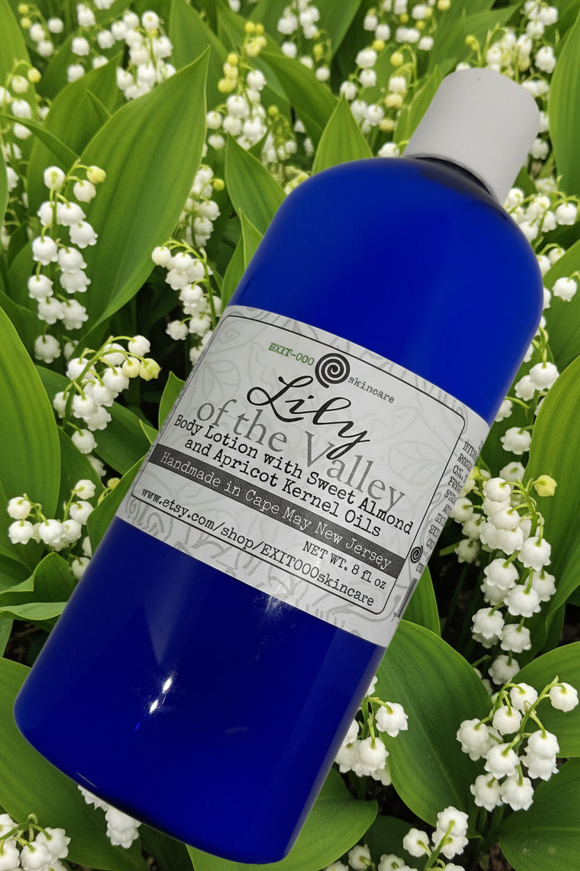 Blue bottle of 'Lily of the Valley' body lotion with a label, surrounded by lily of the valley flowers.